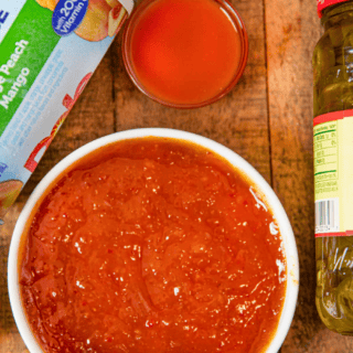 red sauces in bowls, with jalapeno in glass jar, and fruit concentrate on table