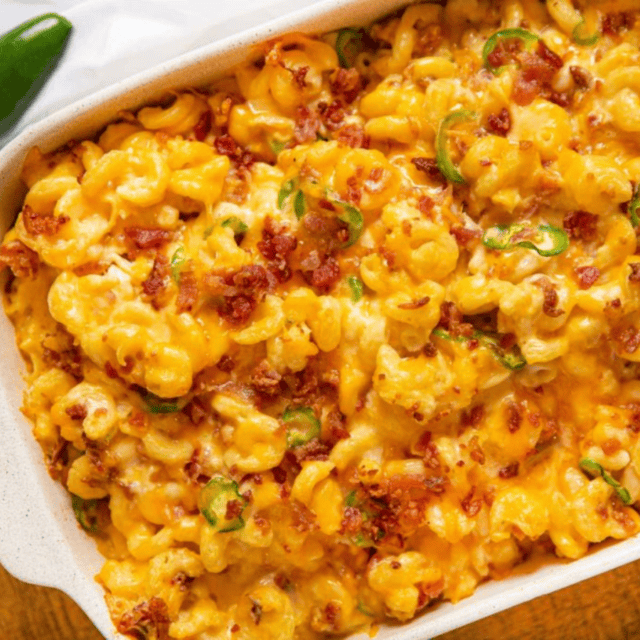 baking dish full of creamy cheesy noodles with bacon and jalapenos