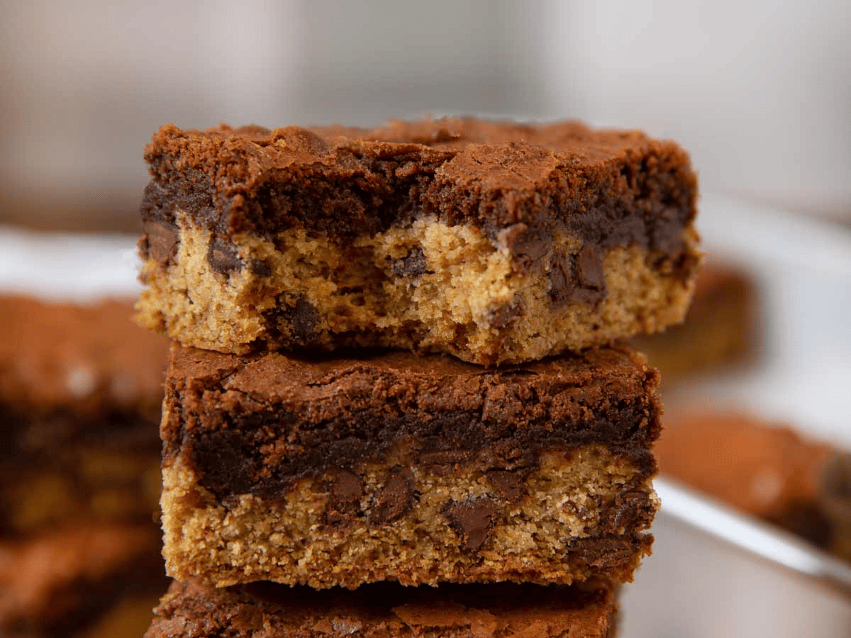 Stack of dessert squares with a bite taken out of one the squares on a table