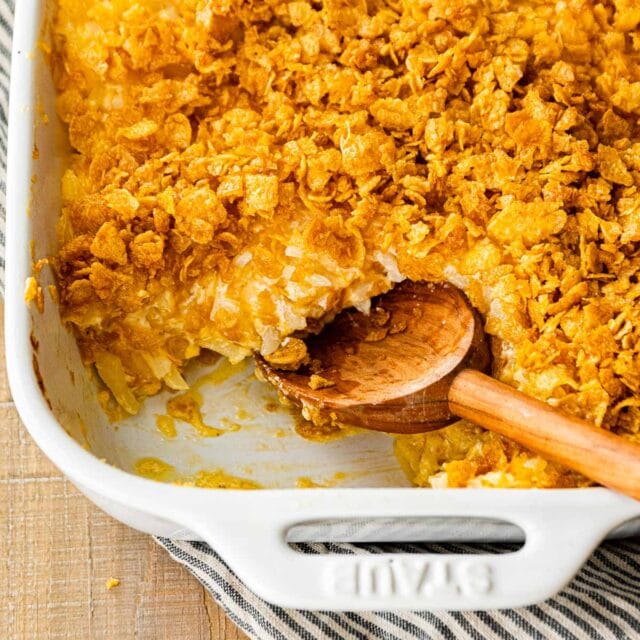 Funeral Potatoes in baking dish with serving spoon