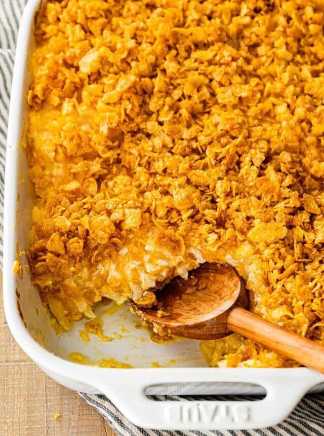 Funeral Potatoes in baking dish with serving spoon