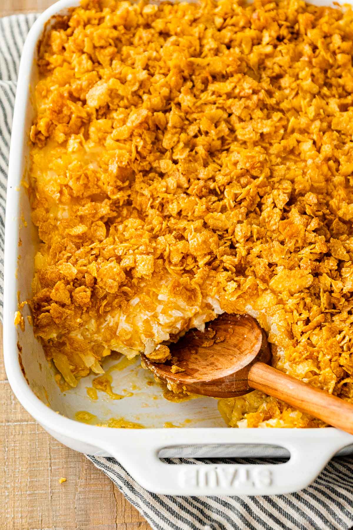 Funeral Potatoes in baking dish with serving spoon