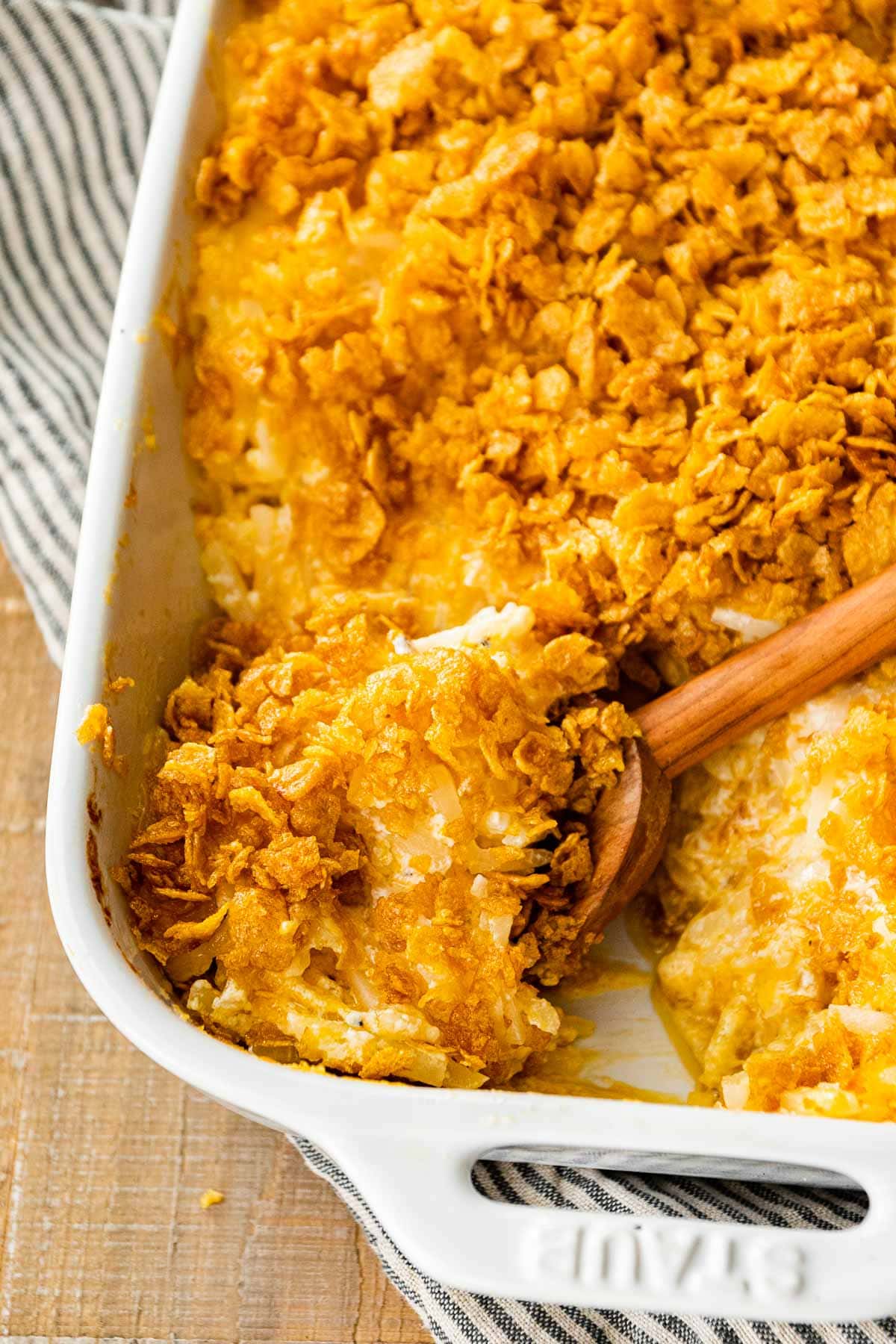 Funeral Potatoes in baking dish with serving spoon