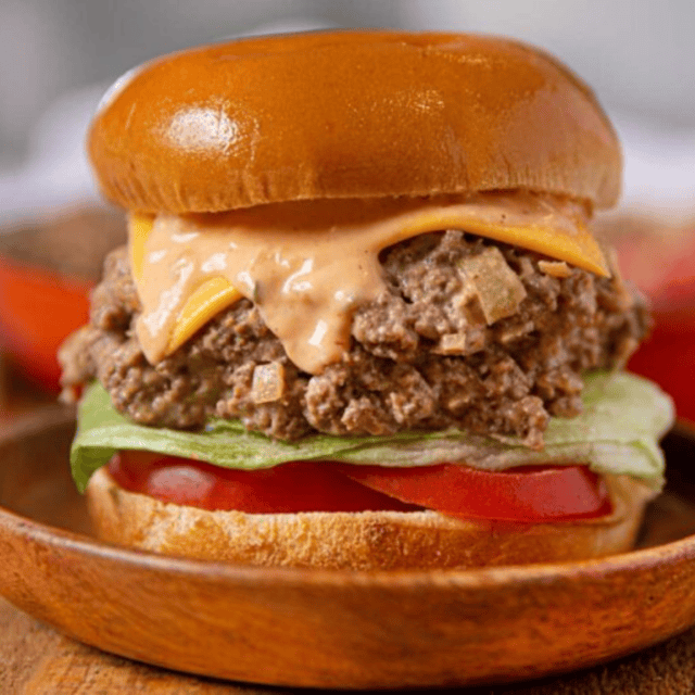 sloppy joes with all the toppings on a wooden plate