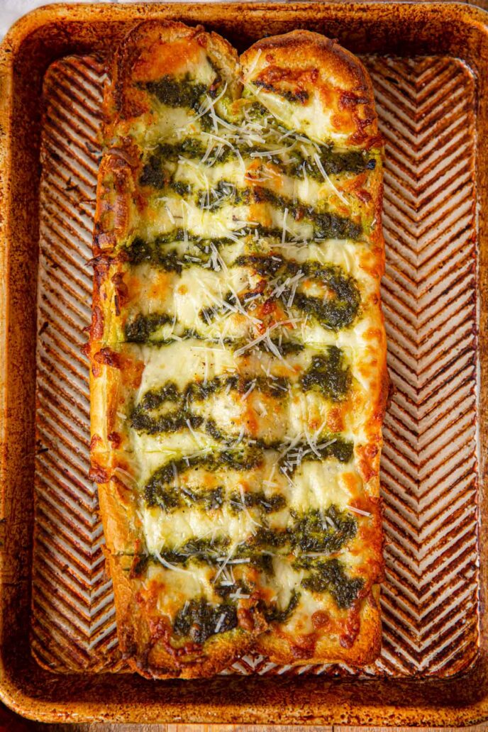 Cheesy Pesto Garlic Bread on baking dish