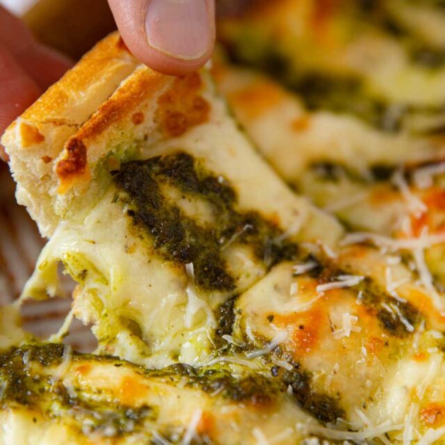 Pesto Cheesy Bread picked up slice