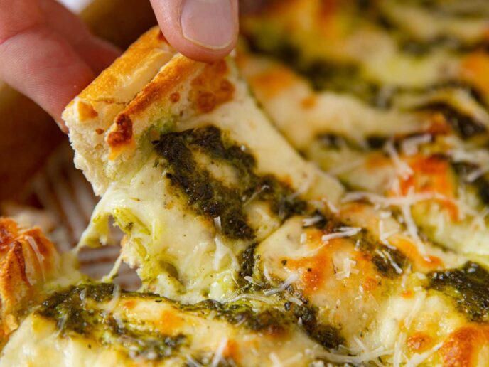 Pesto Cheesy Bread picked up slice