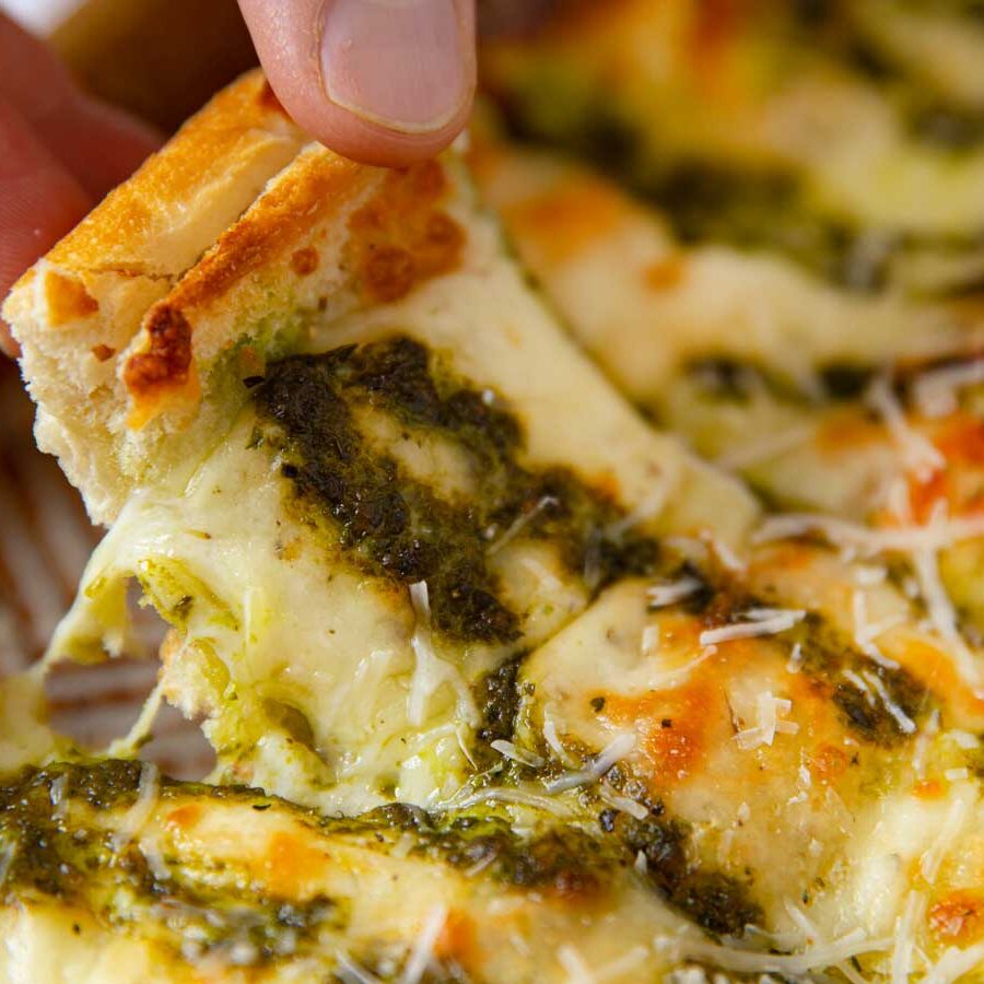 Pesto Cheesy Bread picked up slice