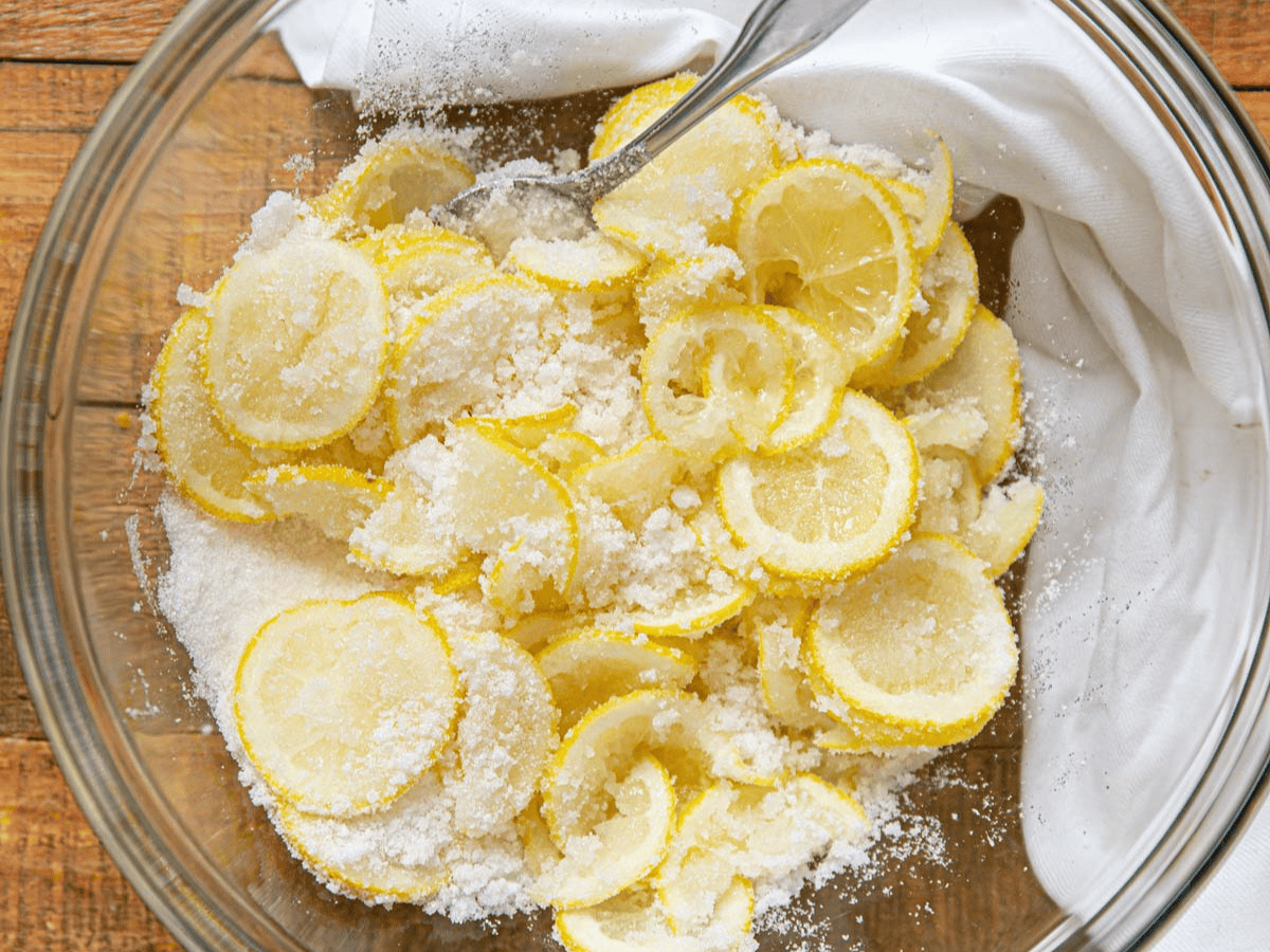 Fruit and sugar in a mixing bowl with a spoon