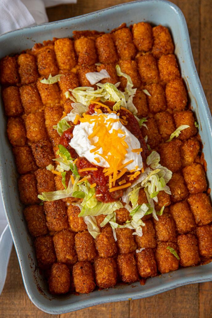 Taco Tater Tot Casserole top down in baking dish with taco meat and cheddar cheese