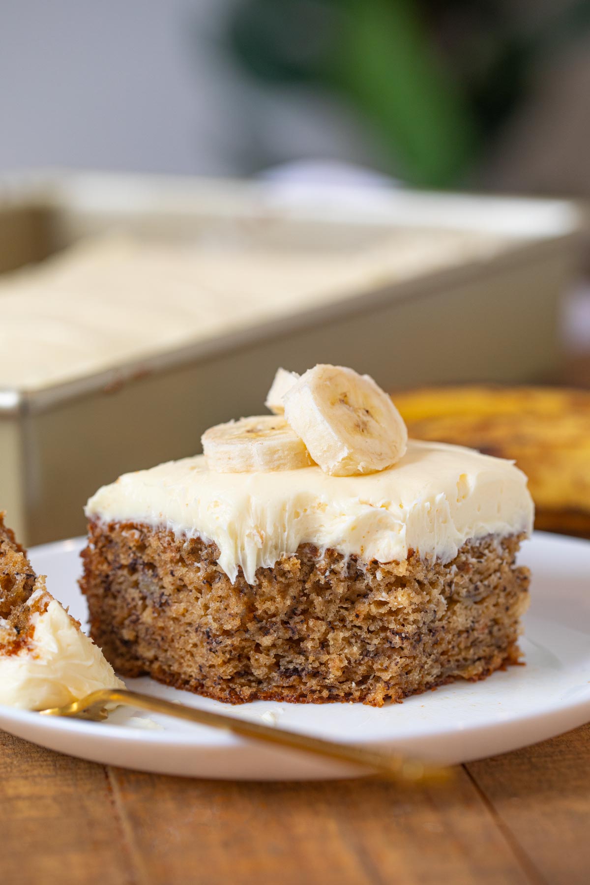 Slice of Banana Cake with frosting and banana slices