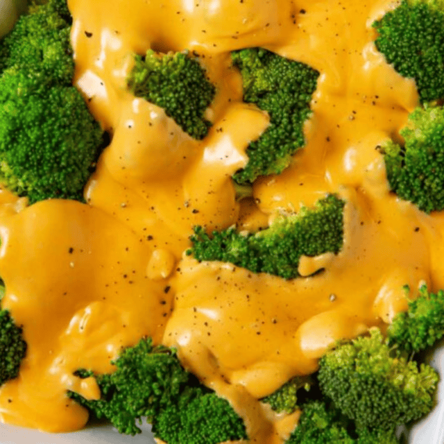Close up of cheese poured on broccoli