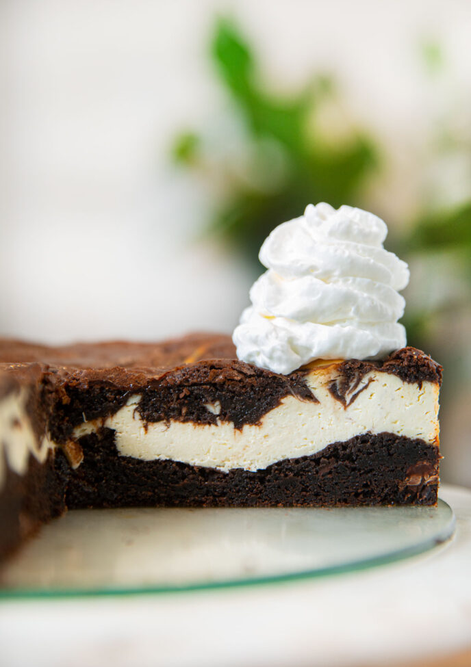 Brownie Cheesecake sliced open with whipped cream