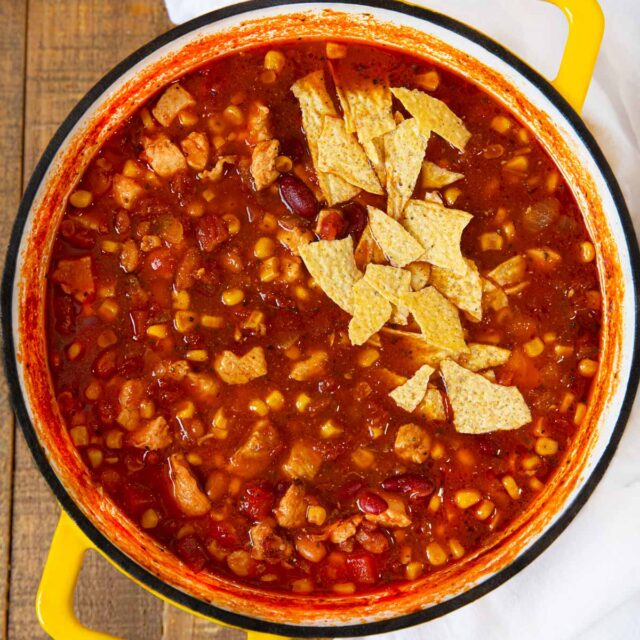 Chicken Taco Soup in pot with crumbled tortilla chips