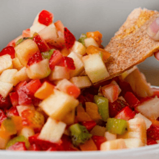 Close up of chip dipping into salsa