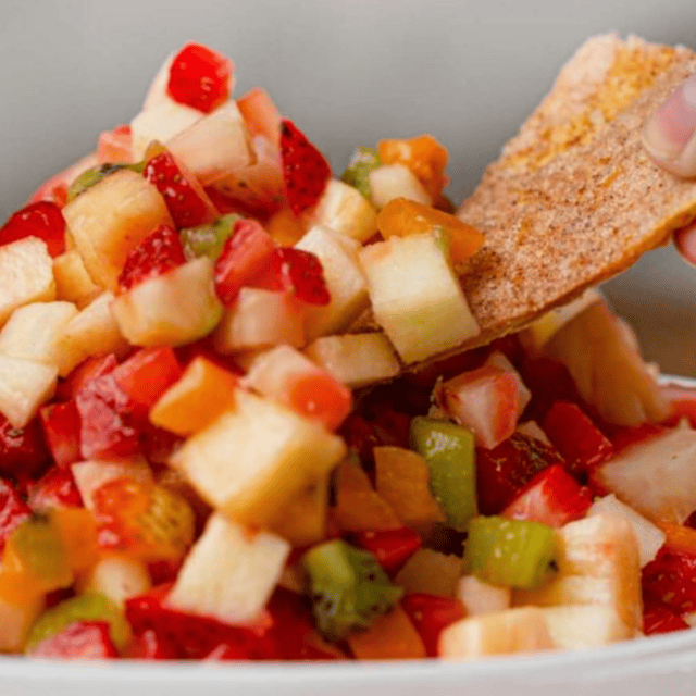 Close up of chip dipping into salsa