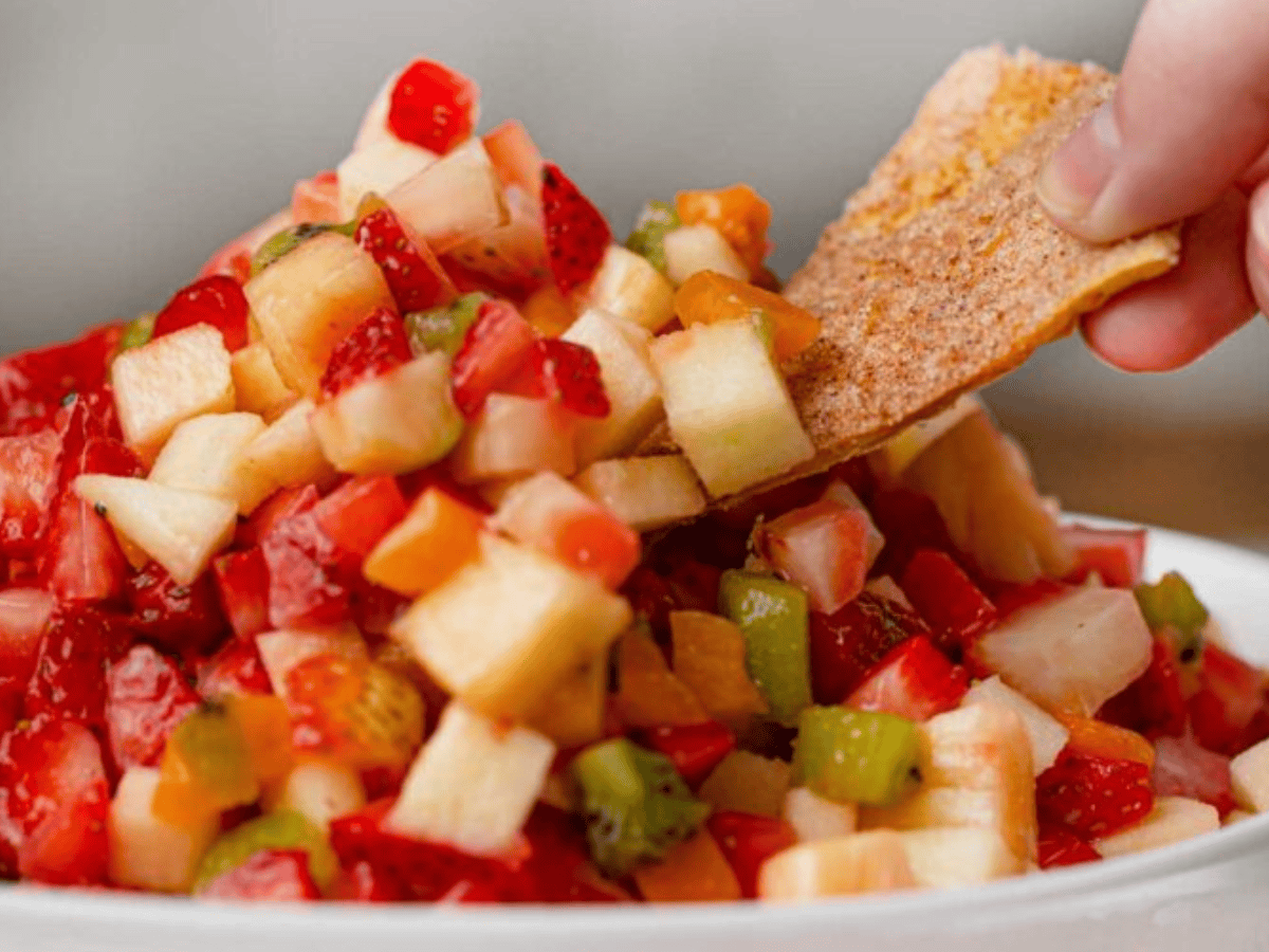 Close up of chip dipping into salsa