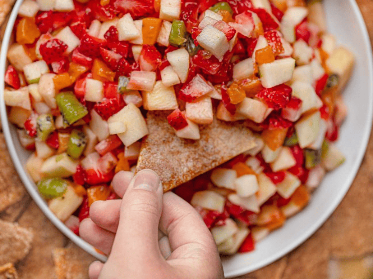 Hand dipping into salsa