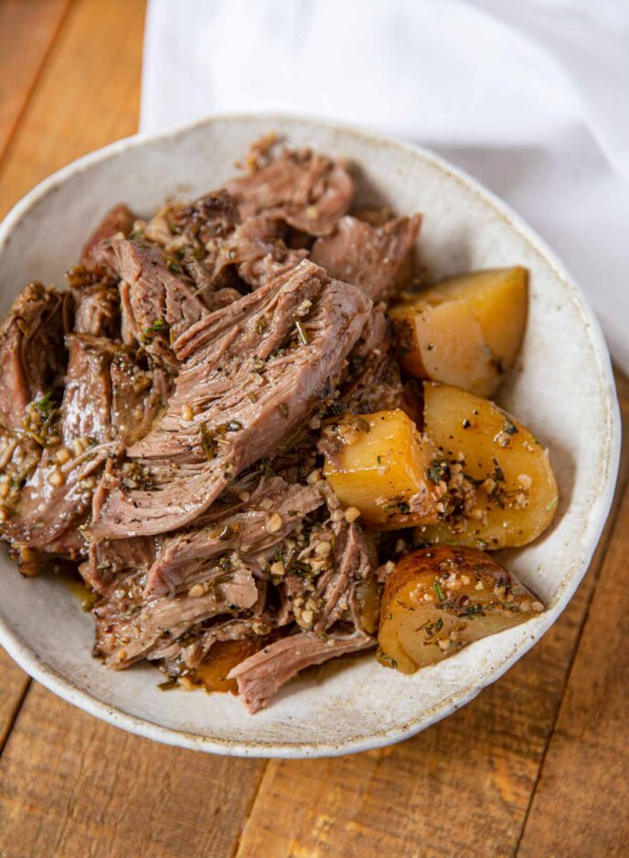 Slow Cooker Leg of Lamb in plate with potatoes