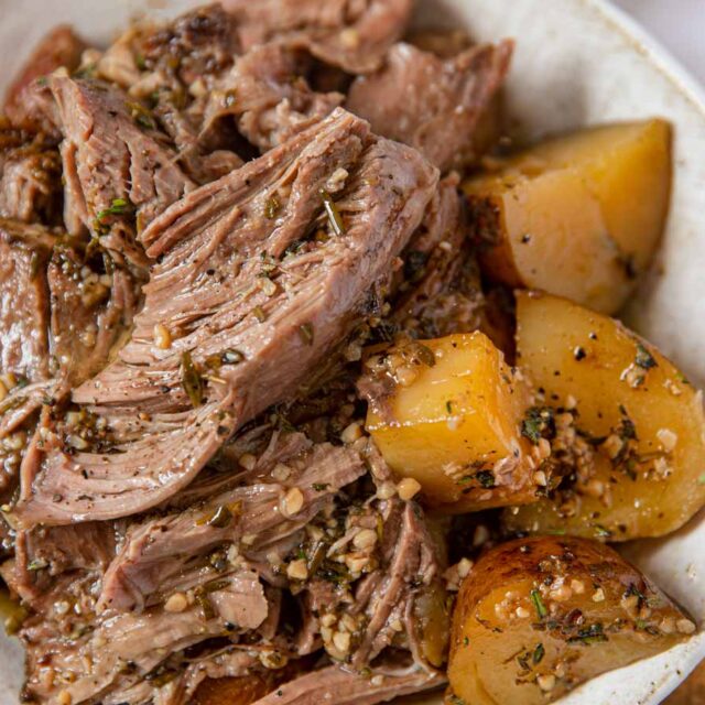 Leg of Lamb on plate with side of potatoes