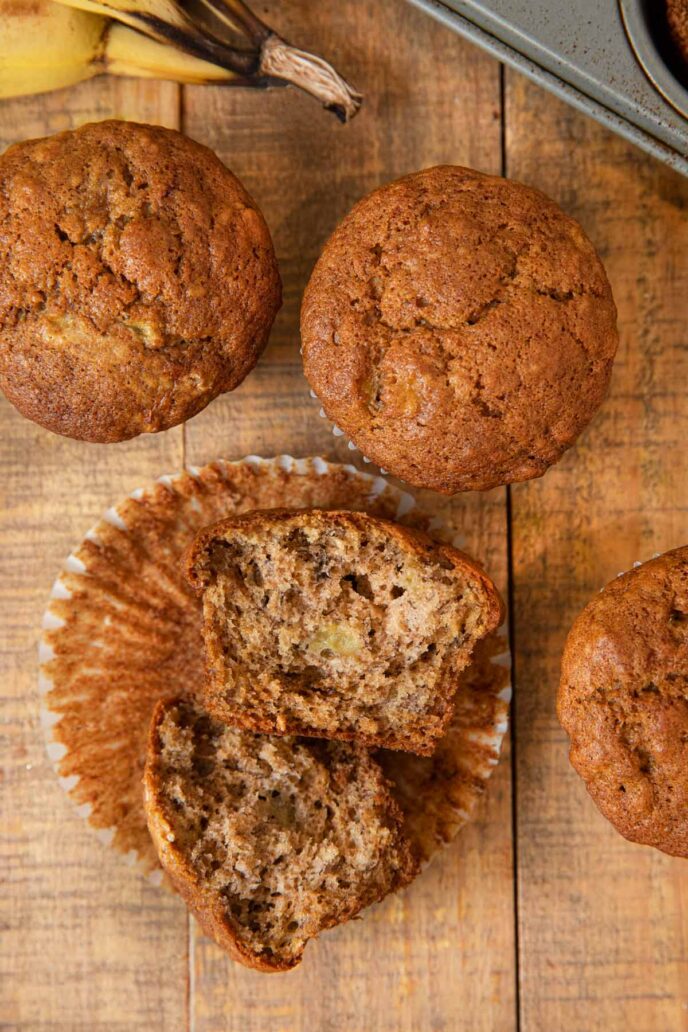 Banana Muffin broken in half in muffin liner on wooden board