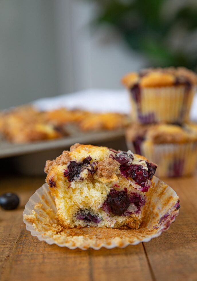 Blueberry Crumb Muffin on board with muffins behind it