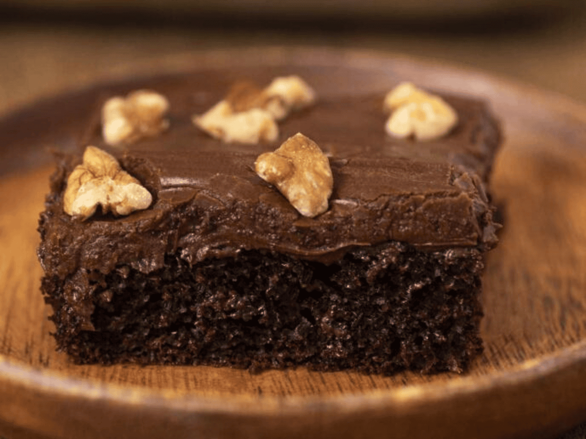Slice of chocolate cake with frosting and walnuts