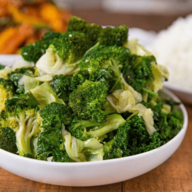 bowl of mixed veggies in a white bowl with other bowls of food in background