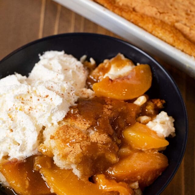 Peaches and Cream Cobbler serving in bowl with whipped cream