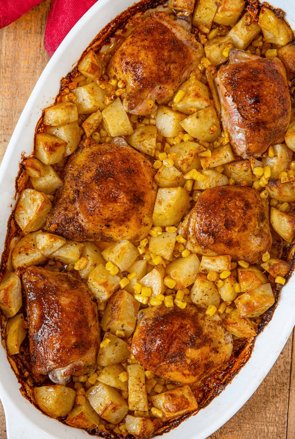 Finished chicken, corn, and potato dinner in a white baking dish