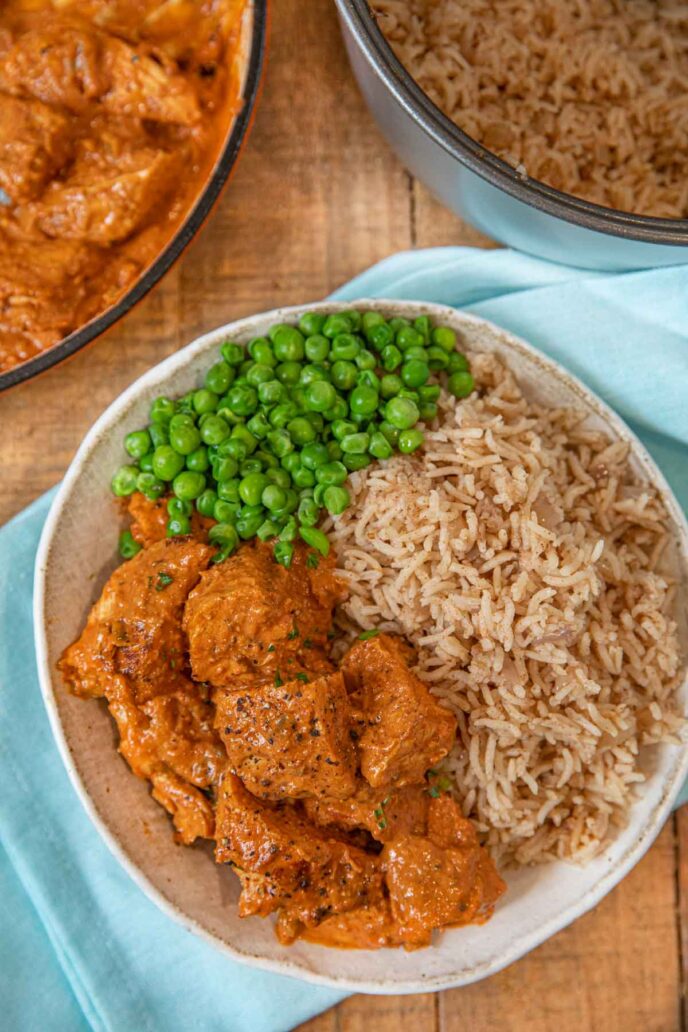 Indian Butter Chicken with peas and rice on plate