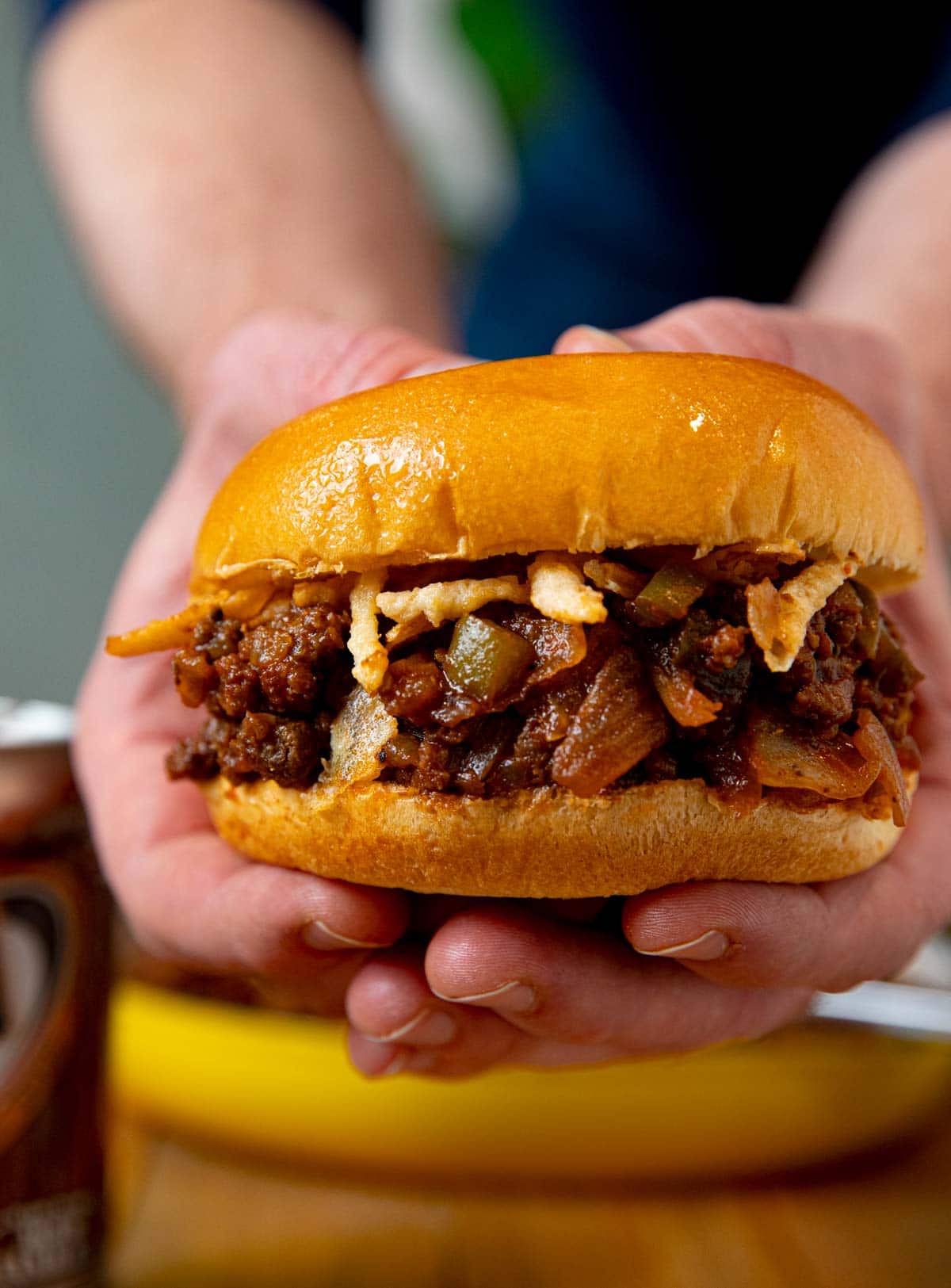 Hand holding sloppy joe sandwich