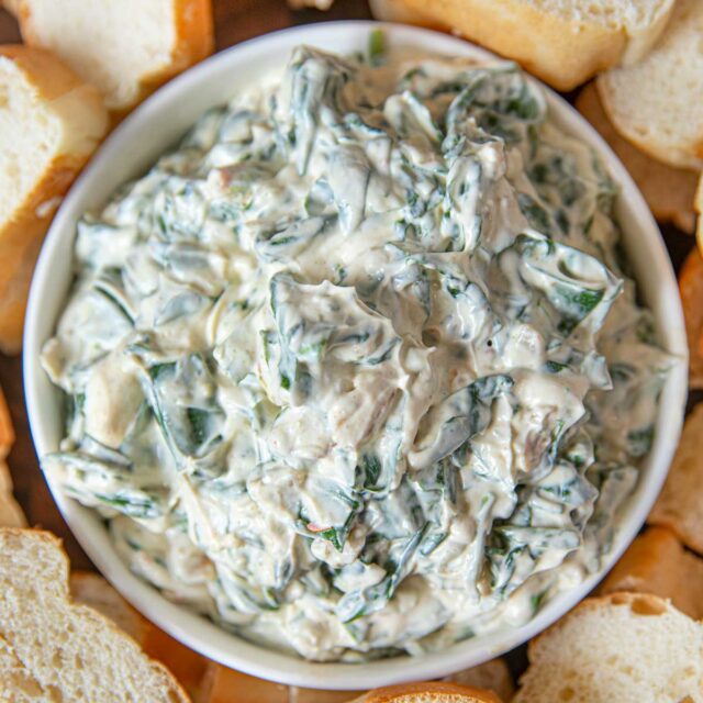 Spinach Dip in bowl with sliced french bread for dipping