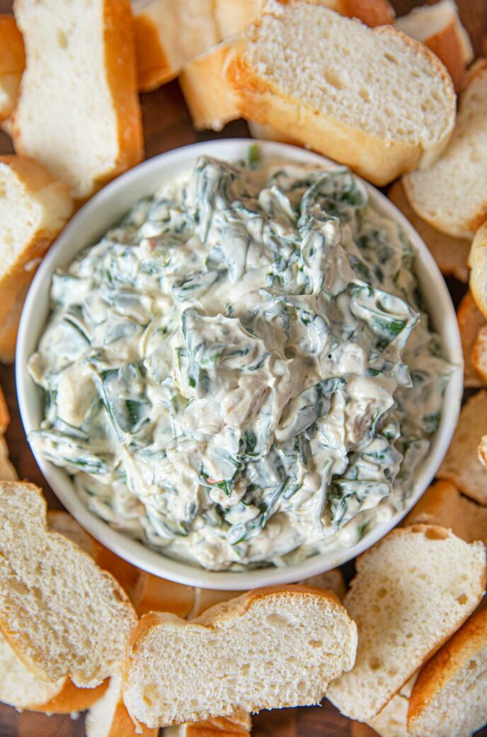 Spimach Dip in bowl with sliced french bread for dipping