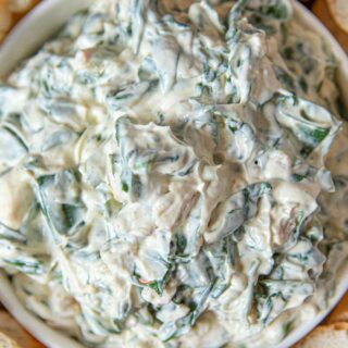 Spinach Dip in bowl with sliced french bread for dipping