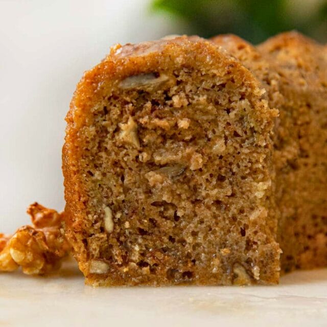 Bundt cake on a cake stand with slice taken out