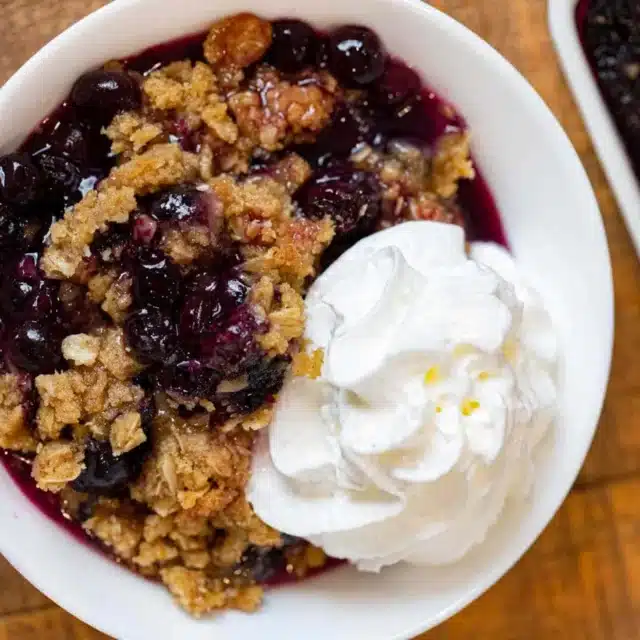 bowl of crisp topped with whipped cream