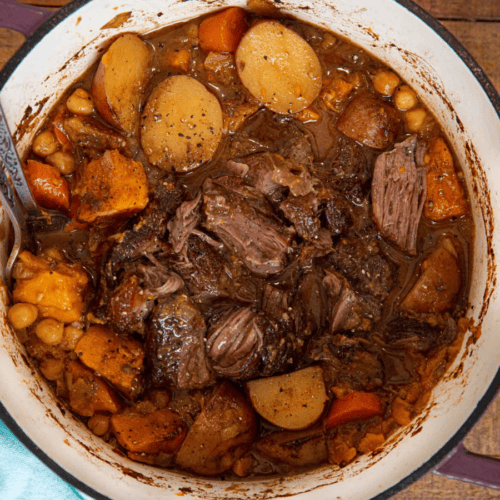 Beef and cut vegetables in pot, cooked but not shredded