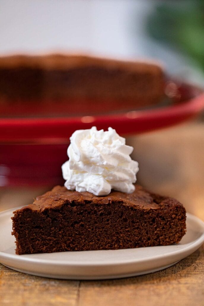 Nutella Cake slice on plate with whipped cream topping