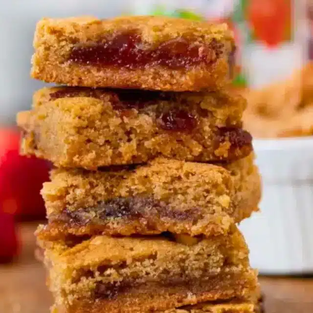 Stack of blondies with strawberries in the background
