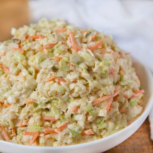Cole slaw piled hit in bowl with napkin on right side