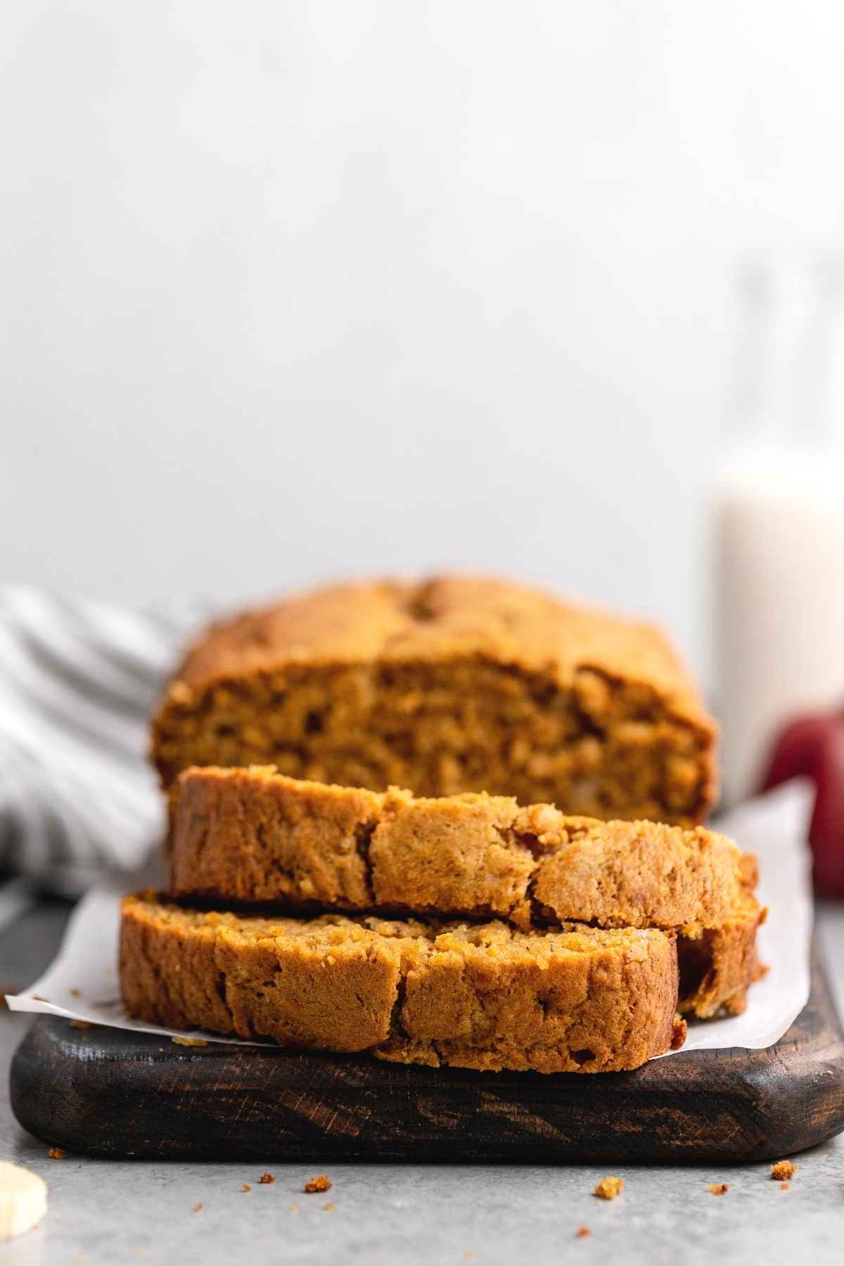 Sliced pumpkin banana bread served on a cutting board.