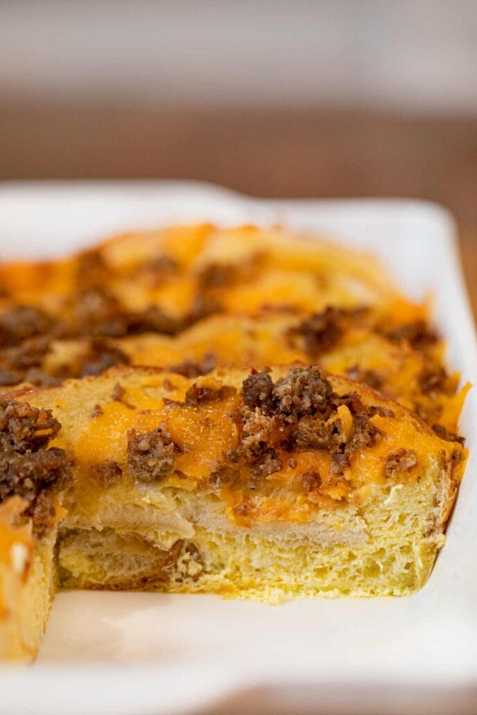 Sausage Cheddar French Toast Casserole in baking dish with slice removed