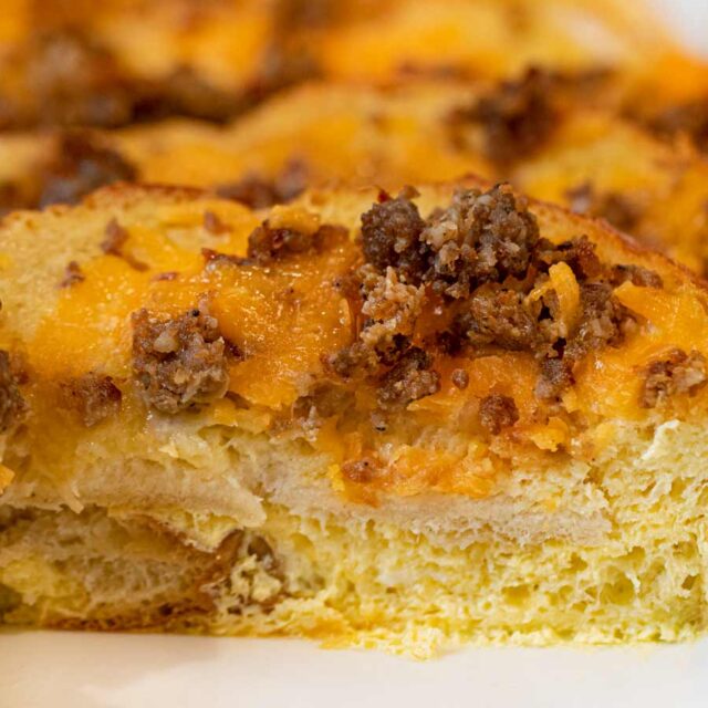 Sausage Cheddar French Toast Casserole in baking dish with slice removed