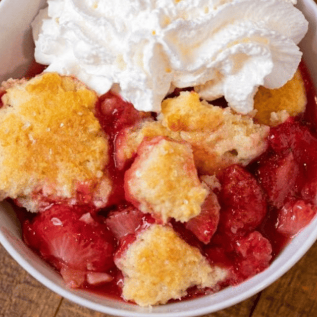 cobbler in a bowl topped with wipped cream