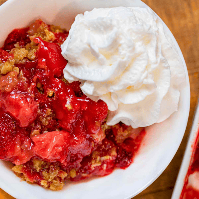 glazed strawberries, oats, and whipped cream in a bowl