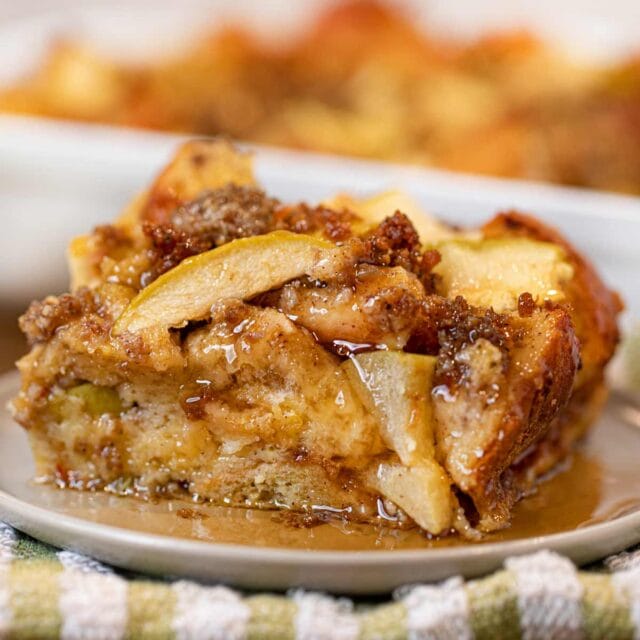 Sausage and Apple Breakfast Bake with syrup on plate and green napkin
