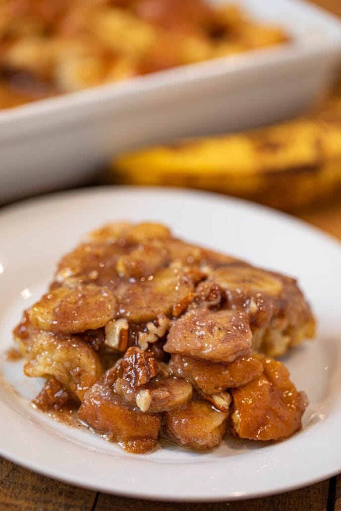 Bananas Foster French Toast Bake on plate with baking dish in the background