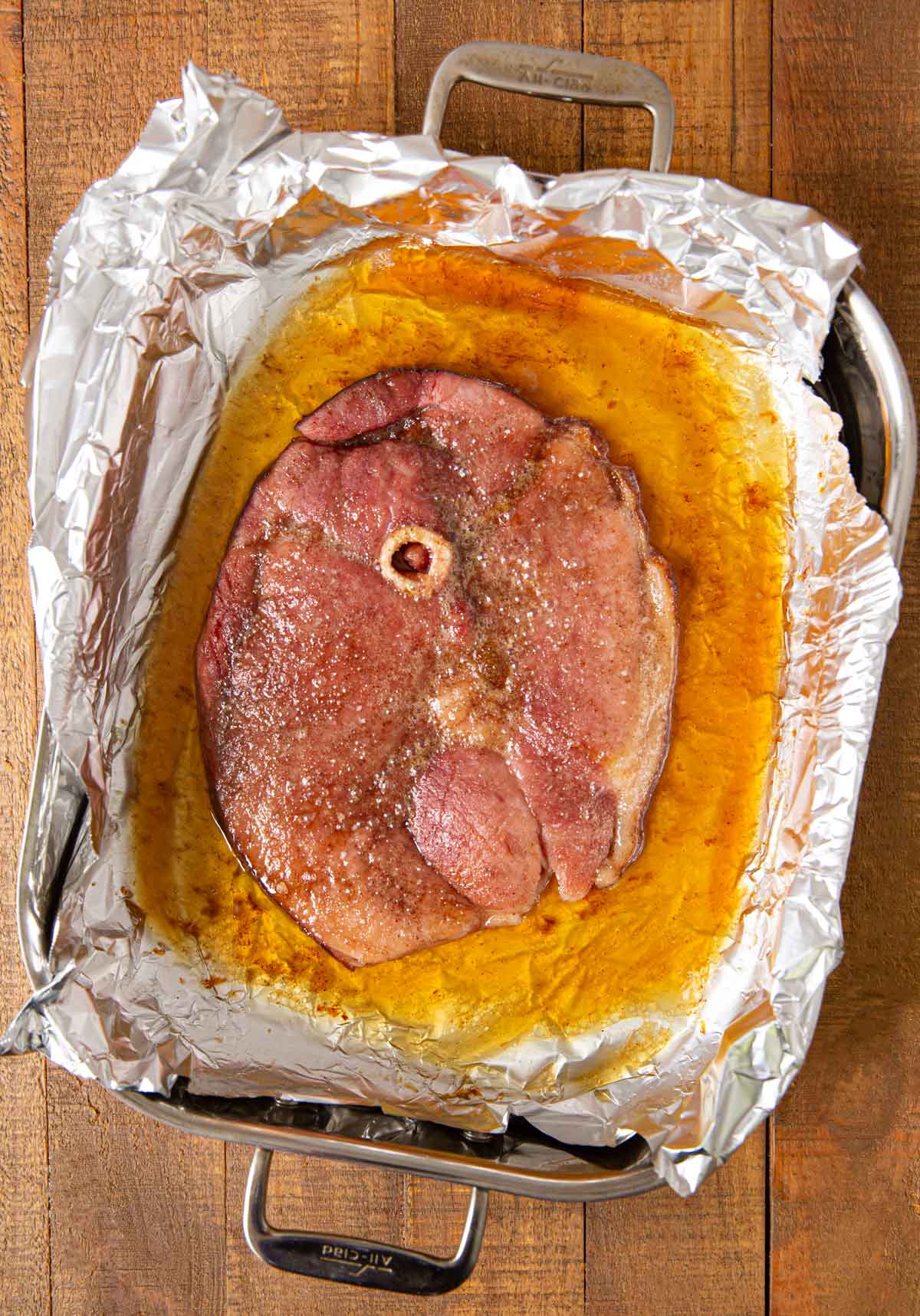 Brown Sugar Ham Steak still bubbling in foil pan