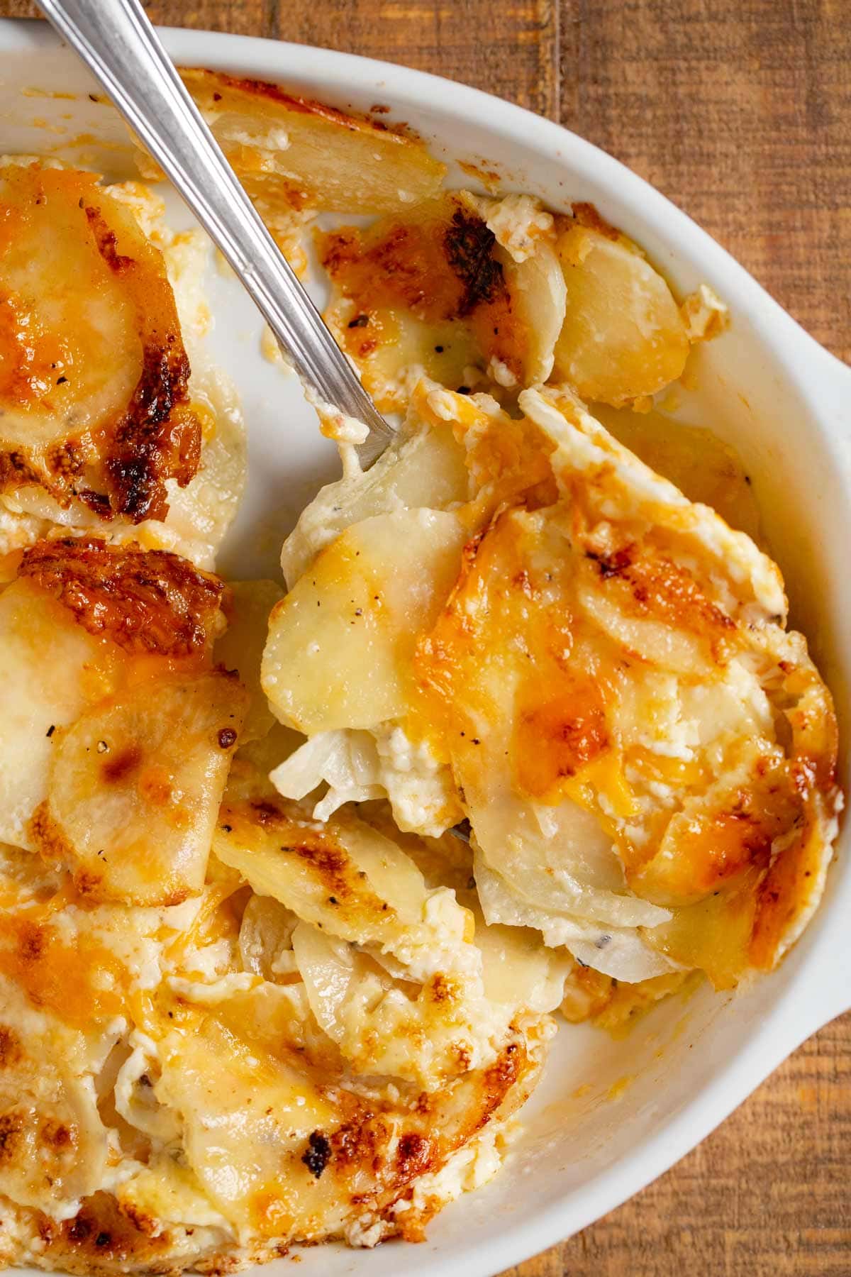 Cheesy Garlic Scalloped Potatoes serving on spoon